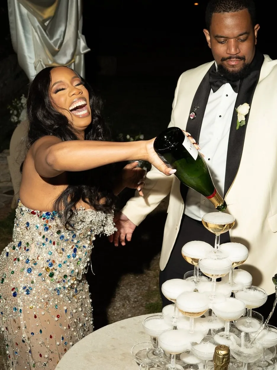Mariée éclatant de rire en versant du champagne sur une tour de coupes