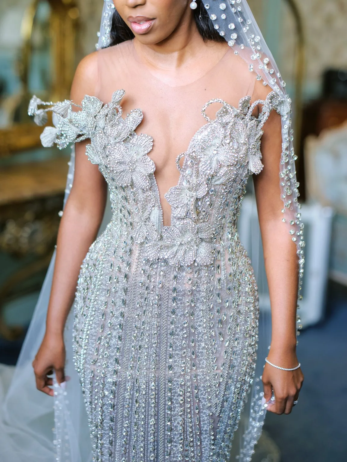 Mariée en robe ornée de perles et voile brodé, en lumière douce
